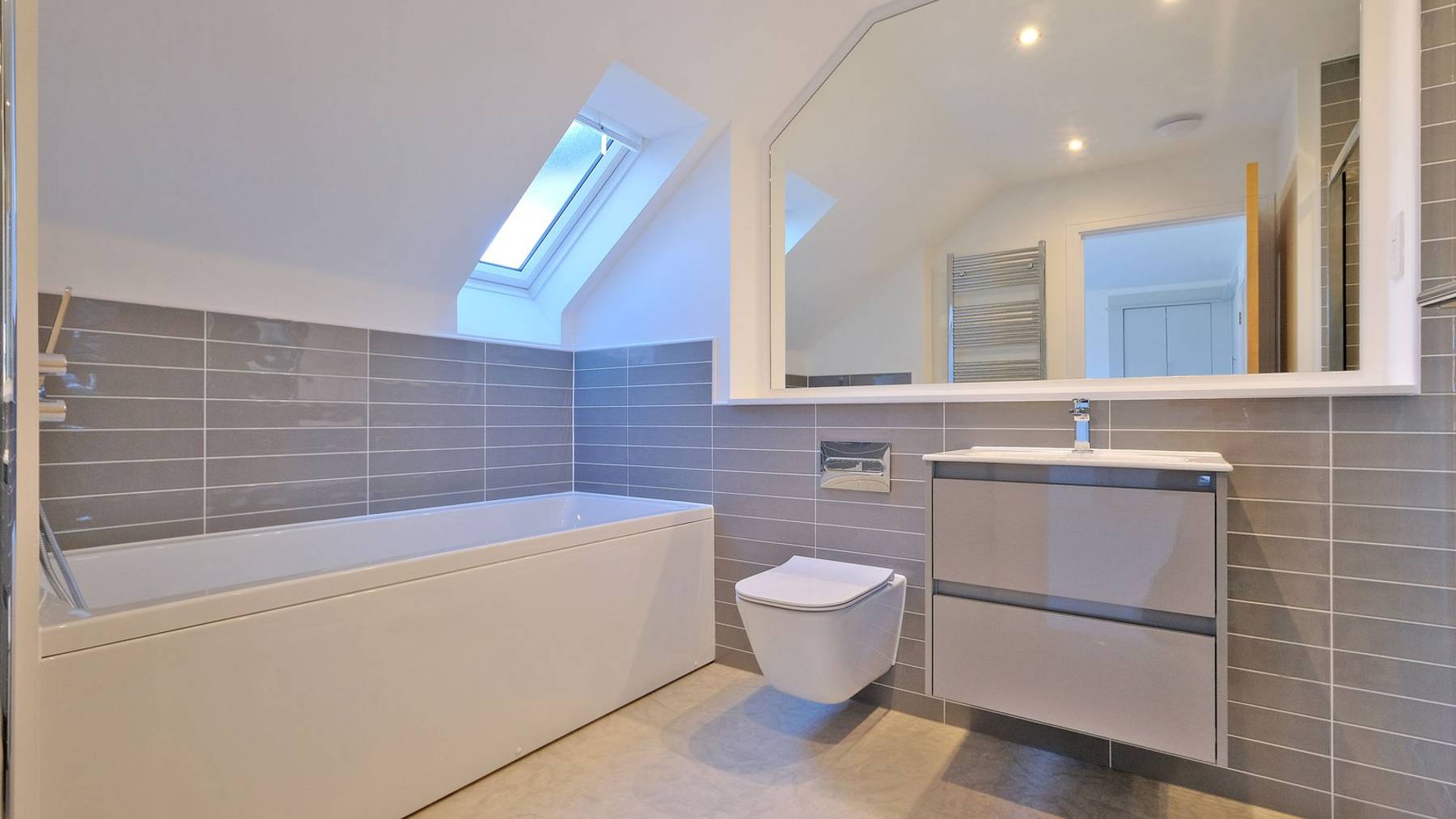 Large ensuite featuring vanity unit and bath 