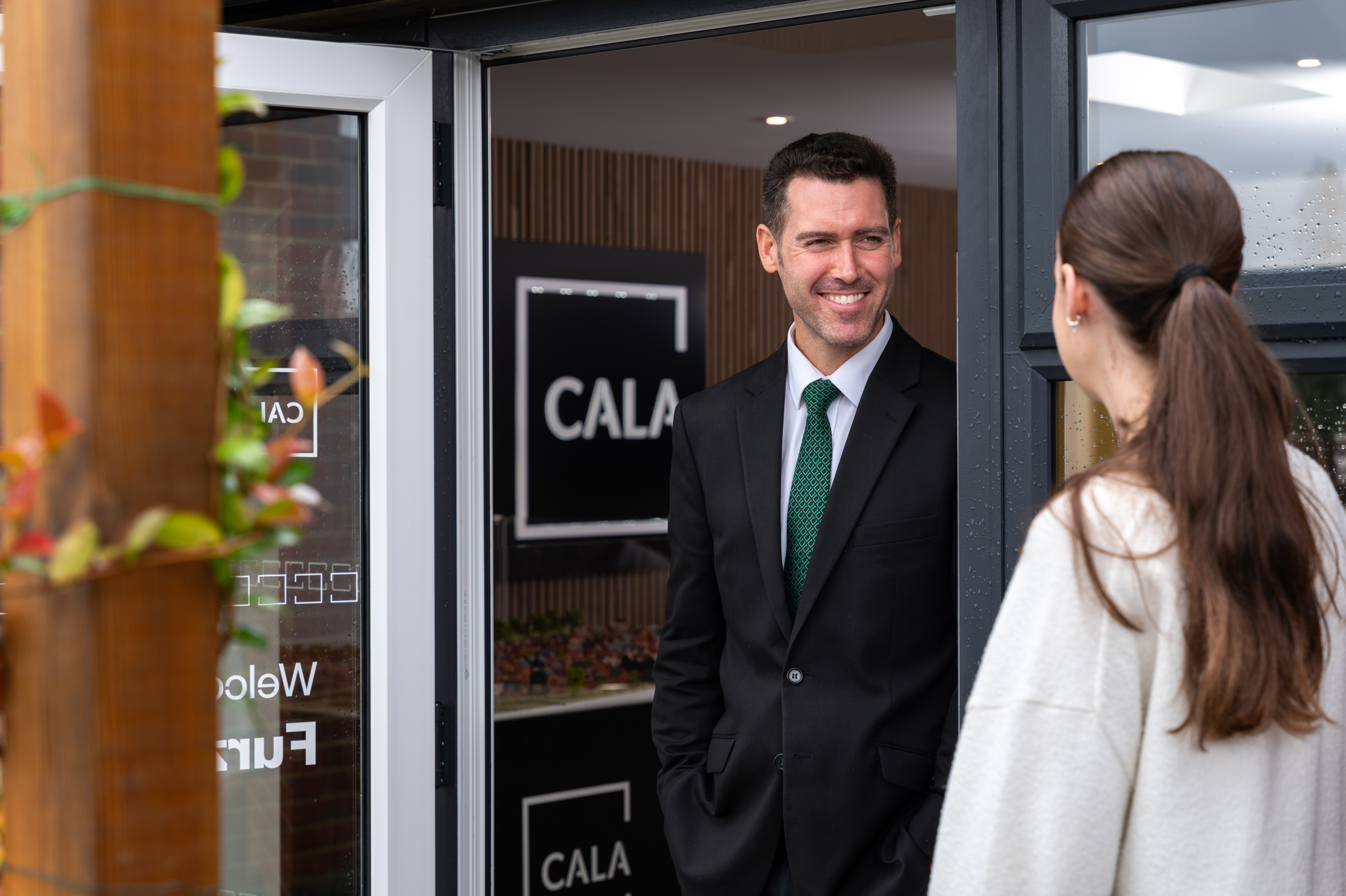Sales consultant greeting a customer at a Cala Homes development